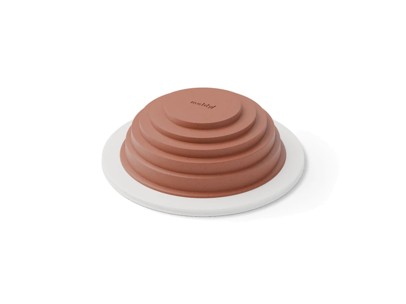 A white printed hump mold with a slab of clay draped over it, shaped into four stepped terraces
